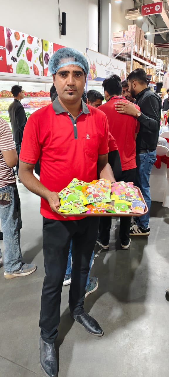 Promoter in a red T-shirt holding Tao Kae Noi samples at LOTS Wholesale